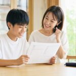 馬渕公開テストの結果を見て笑顔で喜ぶ中学生と保護者