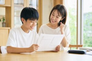馬渕公開テストの結果を見て笑顔で喜ぶ中学生と保護者