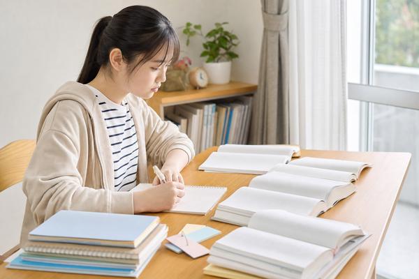 模試の成績表を机に広げて教科ごとの結果を分析する高校生