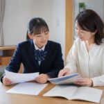 ダイニングテーブルで制服の中学生と保護者が、模試の結果表と入試の案内、過去問を並べて一緒に確認している様子