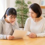 明るいダイニングで通知表を一緒に見つめる中学生と保護者
