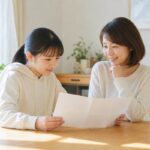 明るいダイニングで通知表を一緒に見る中学生と母親
