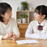 通知表を前に、母親と中学生が明るいダイニングで落ち着いて話し合う様子