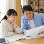 明るいダイニングで中学生の娘と父親が成績表と高校受験資料を見比べる様子
