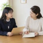 制服の高校生と母親が自宅のダイニングで通知表を前に落ち着いて話し合う様子