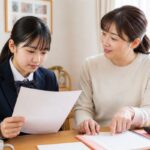 進学校の最初の定期テストの答案を母親と一緒に見返している高校生