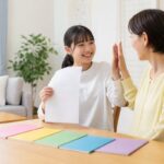定期テストの高得点の答案を見せる中学生と、笑顔でハイタッチを返す保護者