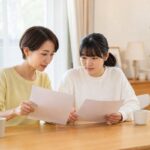 明るいリビングで通知表と模試の結果を見比べる母親と中学生の娘