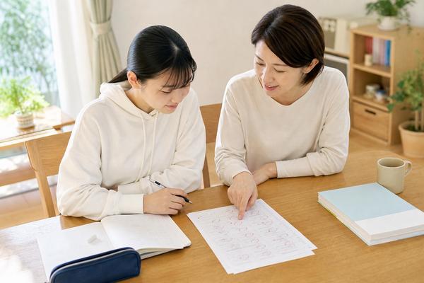 模試の答案を一緒に見ながら、取り戻せる失点を確認する高校生と保護者