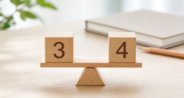 3と4の数字が書かれた木の積み木が天秤の上でつり合い、評定3.5が3と4の中間にあることを表した写真