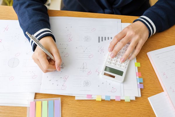 返ってきた模試の答案を電卓と付箋で仕分けし、必要な点数を逆算している生徒の手元