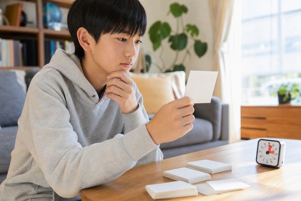 カードの答えを見ずに思い出しながら、タイマーを使って解き直している中学生