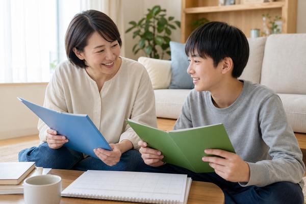 保護者と中学生の息子が2種類のファイルを見比べて受験部門を相談している様子