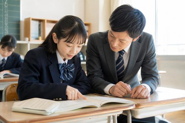 教室で先生に教科書本文の根拠の探し方を教わる制服の中学生