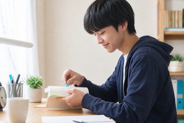 間違えた単語のページに付箋を貼り、復習を進める自宅学習中の高校生