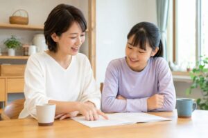 明るいダイニングで通知表を一緒に見ながら笑顔で話す母親と中学生の娘