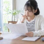 返却された英語の定期テストの答案を手に取り、失点の原因を考えている中学生