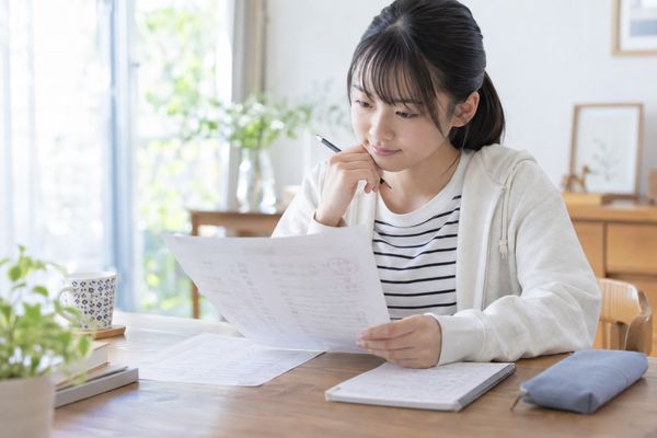 返却された英語の定期テストの答案を手に取り、失点の原因を考えている中学生