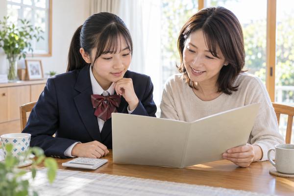 通知表と電卓を前に中学の内申点を一緒に確認する母親と中学生