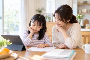 ダイニングでタブレットの学習画面と学校のテスト用紙を見比べる小学生と母親