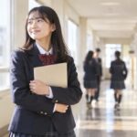 通知表を受け取り、明るい校舎の廊下でうれしそうにしている中学生