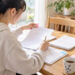 自宅のテーブルで返却された実力テストの答案を見直し、ピンクの付箋を貼っている中学生