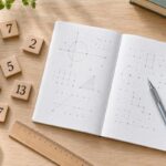 素数の数字タイルと方眼ノート、鉛筆と定規を並べた整数の学習イメージ
