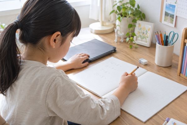 タブレットを閉じたあと、ノートに自分の力で問題を解き直す小学生