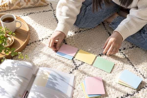 床に広げた英語のノートと色分けした付箋を並べ、どこでつまずいているかを仕分けしている手元