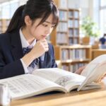 図書室で漢文の学習ガイドと教科書を見比べている制服の高校生