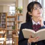 明るい図書室の窓辺で、漢文の参考書を開いて考えている制服姿の高校生