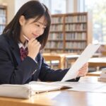明るい学校図書室で、マーク式の漢文問題と解説を見比べて納得した表情の高校生
