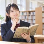 図書室で漢文の参考書を開き、ひらがなに直す漢字を確認する高校生