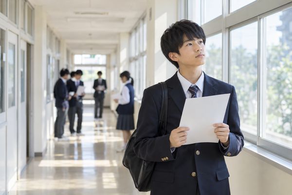 返却されたテストを手に、何点なら安心なのか分からず立ち止まっている中学生