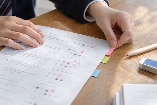 返却された答案の失点を付箋で種類ごとに分けている高校生の手元