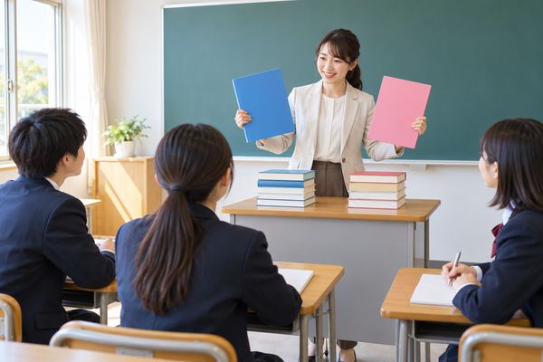教室で2枚のカードを示しながら、古典に古文と漢文があることを説明する先生