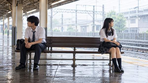 雨宿りの駅のベンチで、背を向けて座る二人の高校生