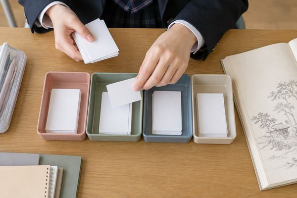 無地のカードを四つの浅い箱へ仕分けしている手元を真上から見た様子