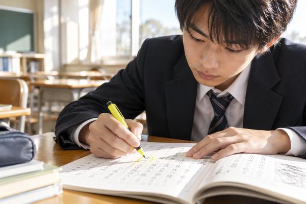 漢文の本文に蛍光ペンで印を付けながら、字と直後の動詞をまとめて確認している高校生
