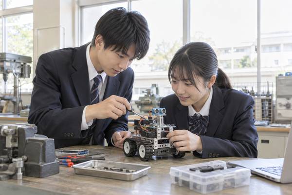 工科高校の実習室で、機械を組み立てながら学んでいる高校生。普通科と工科では学ぶ内容が違う