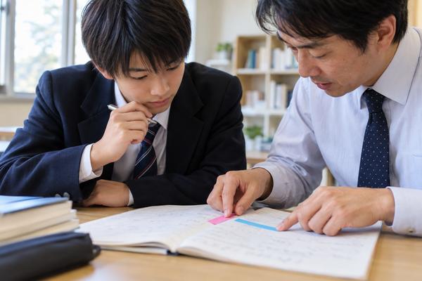 しおりを使って返り点と再読文字の読む順番をたどる高校生と先生