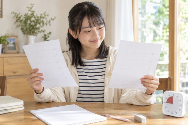 前回と今回の答案を見比べ、正答のまま速くなったか確かめている中学生