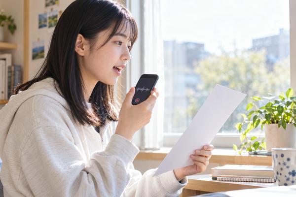 短い英文の音読をスマートフォンで録音して練習する高校生
