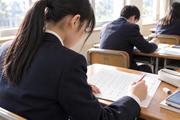 明るい教室で短い漢文の演習問題に印を付けていく制服姿の高校生