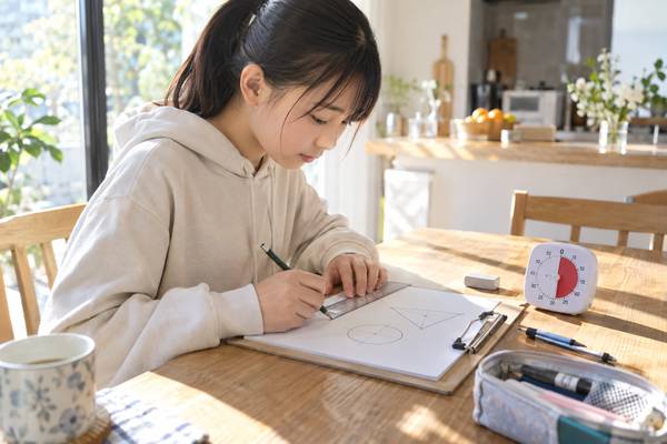 自宅の机で、中学生が学習タイマーを置いて時間を計りながら、資料を見ずに作図を再現している様子