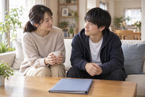 明るいリビングで向き合い、テストの結果について穏やかに話す保護者と中学生