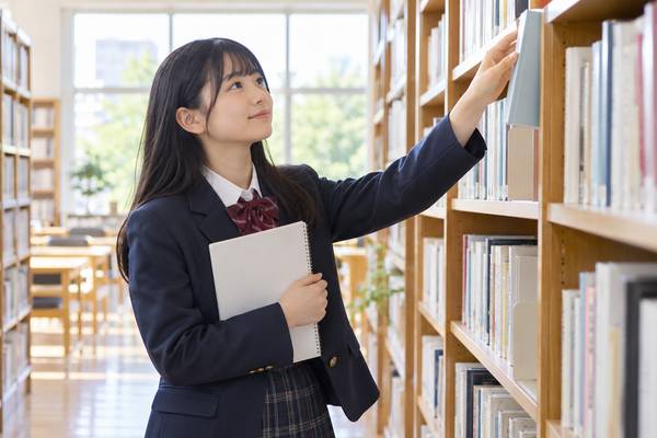 図書室の本棚から古典の教材を選び、今日から勉強を始めようとする高校生